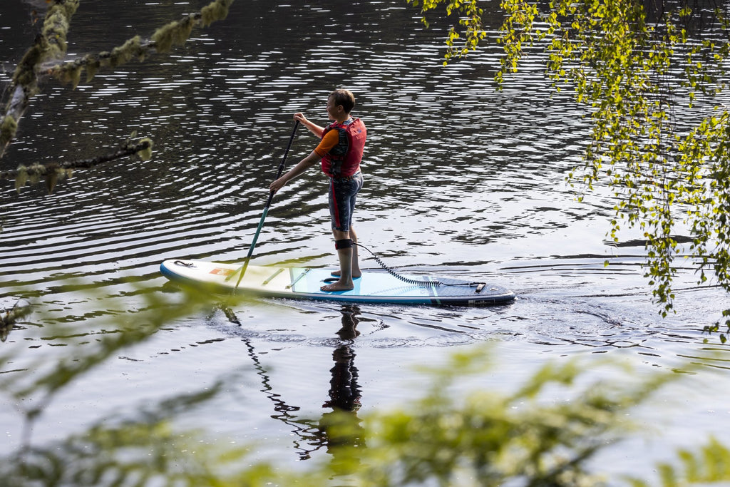 Young paddle boarding on a lake